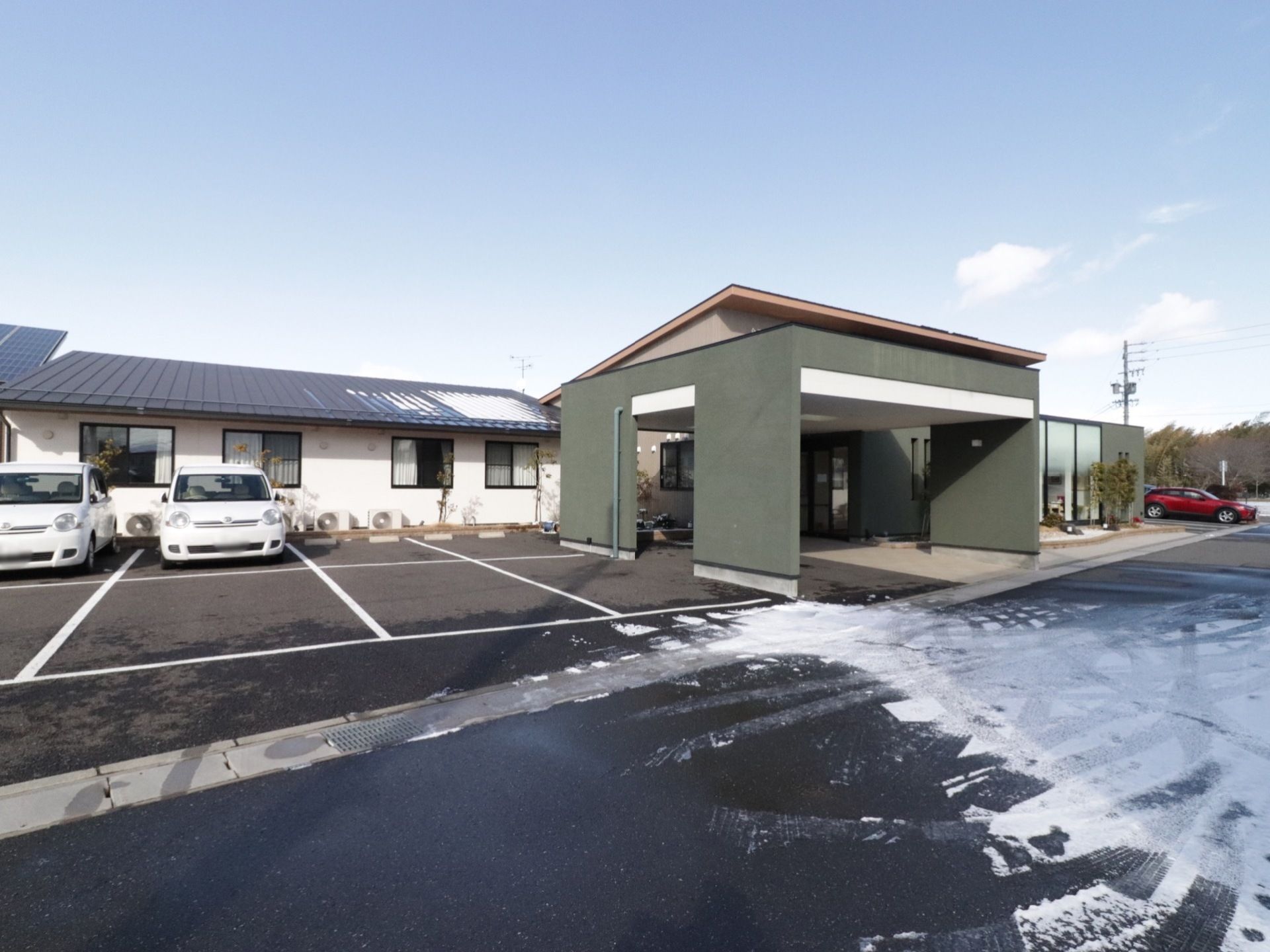 平屋建ての施設になっており、多くの車が収容できる駐車スペースも用意されている。玄関付近には大型屋根が設けられている。