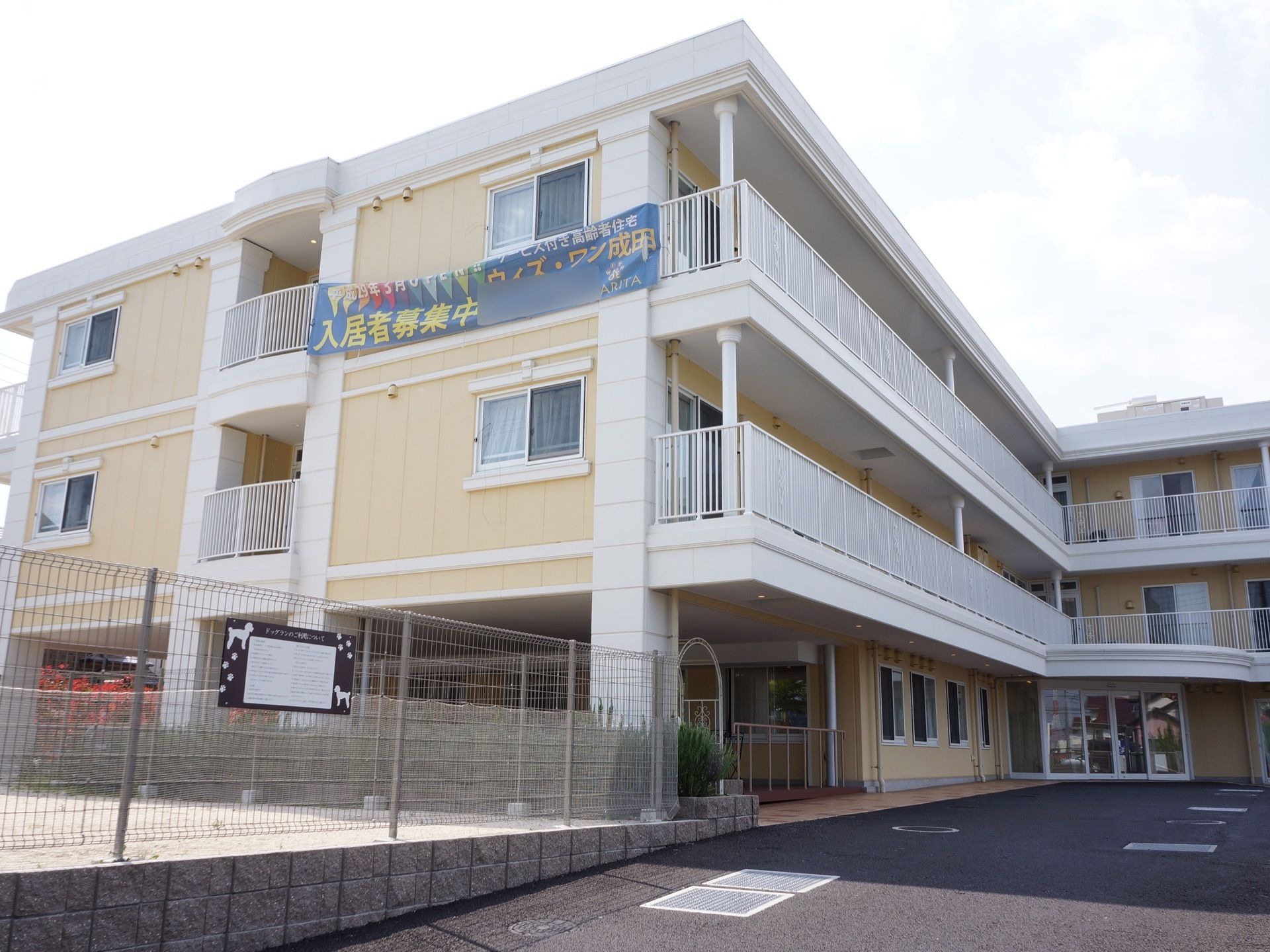 斜め下から見上げた施設建物。２階から上の居室には全てベランダがあり、緊急時の避難経路として使えるようにもなっている。