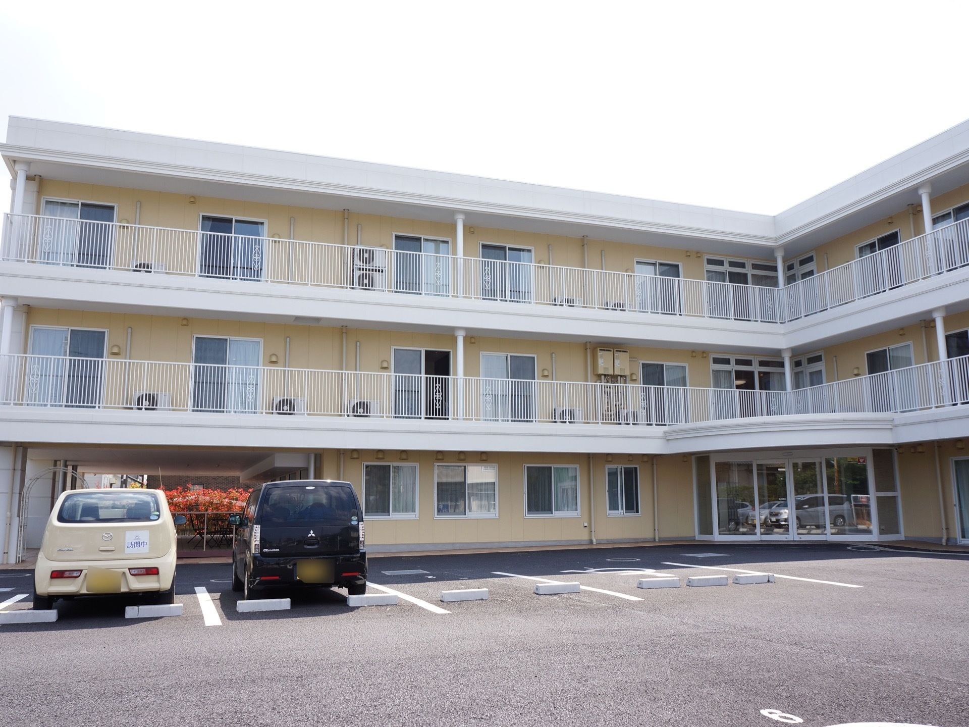 施設の正面玄関は、建物が直角に曲がっている場所に設置されている。広い駐車場が用意され、アスファルト舗装されている。