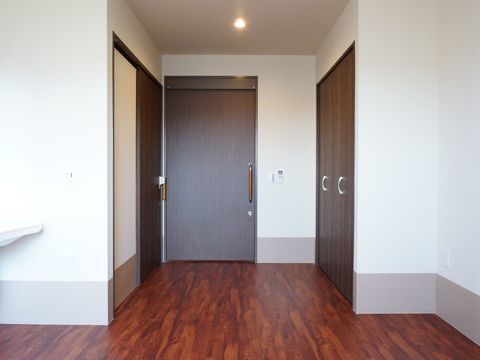 ベッド用のスペースから居室の玄関側を見たところ。トイレと収納クローゼットがそれぞれの室内に用意されている。