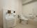 広々としたスペースが確保されているトイレは、オストメイト対応になっている。右端の天井付近には、収納棚が設置されている。