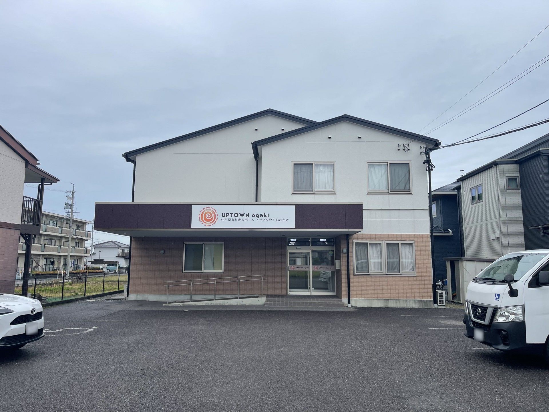 建物の壁に並行して設置されている、スロープのある二階建て施設外観