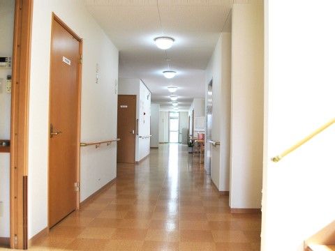 白い壁と木目の床の、幅が広く真っ直ぐな廊下。突き当りにはあかり取りの窓がある。壁部分には隙間なく木製の手すりが設置してある。