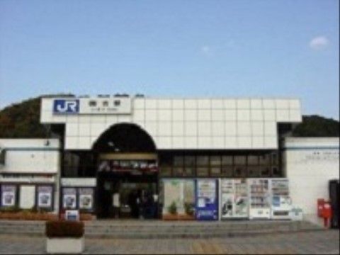 駅の入り口部分は大きなアーチ状になっている。白い屋根に駅名が書かれた看板が付いている。外には自動販売機が設置されている。