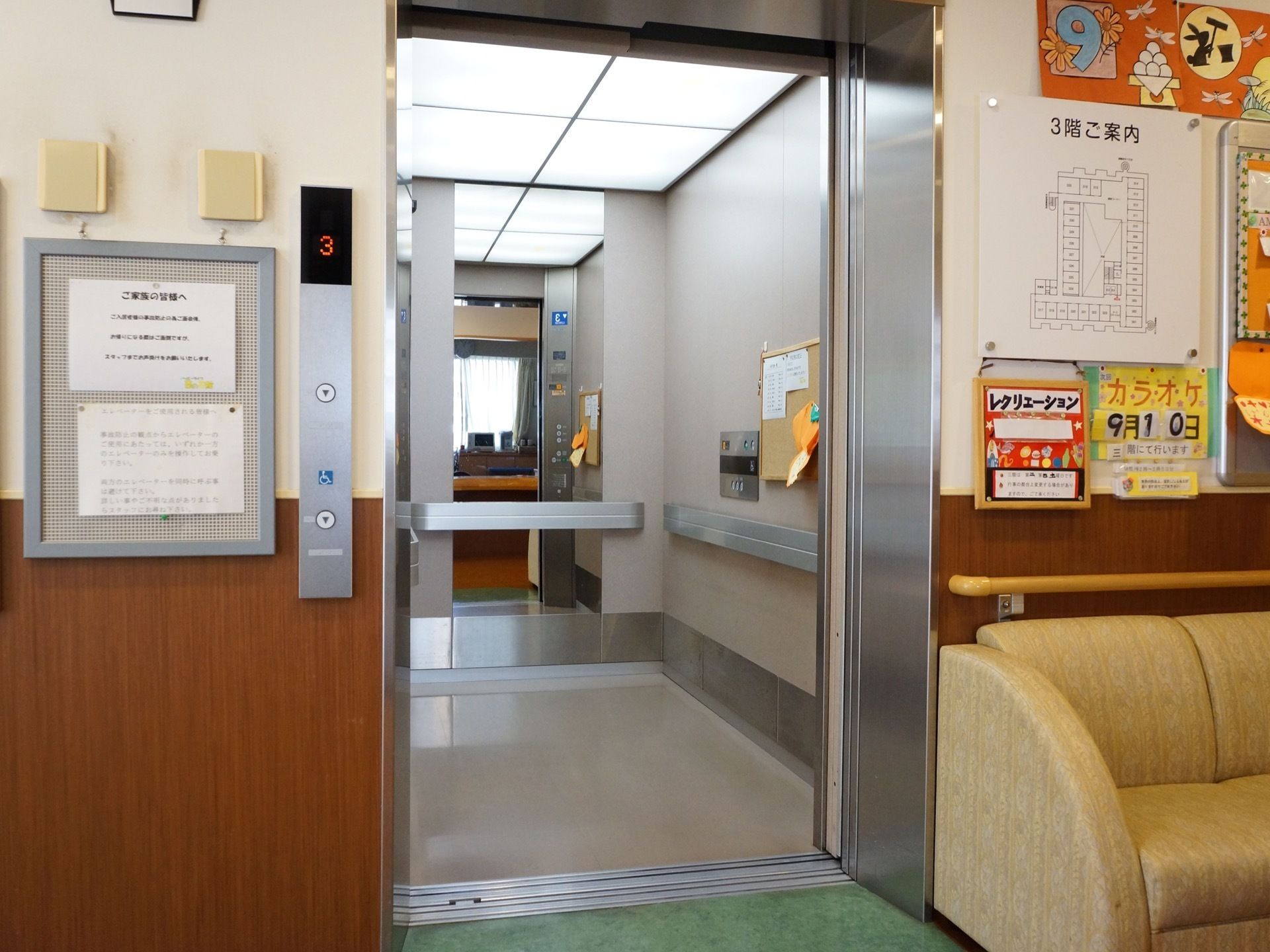 車椅子をご利用の方も使用しやすいエレベーターが完備されている。ドア横にはソファ、施設の案内図やイベント情報など掲載している。
