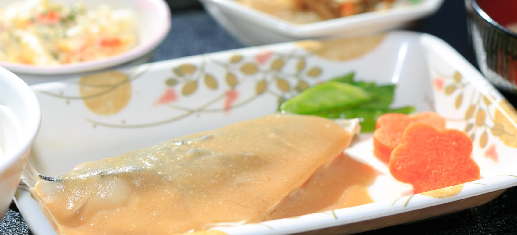 さやえんどうと花型のにんじんを添えた魚の煮つけ