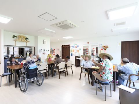 神棚が飾られているホワイト調でまとめられている部屋に集まっている入居者