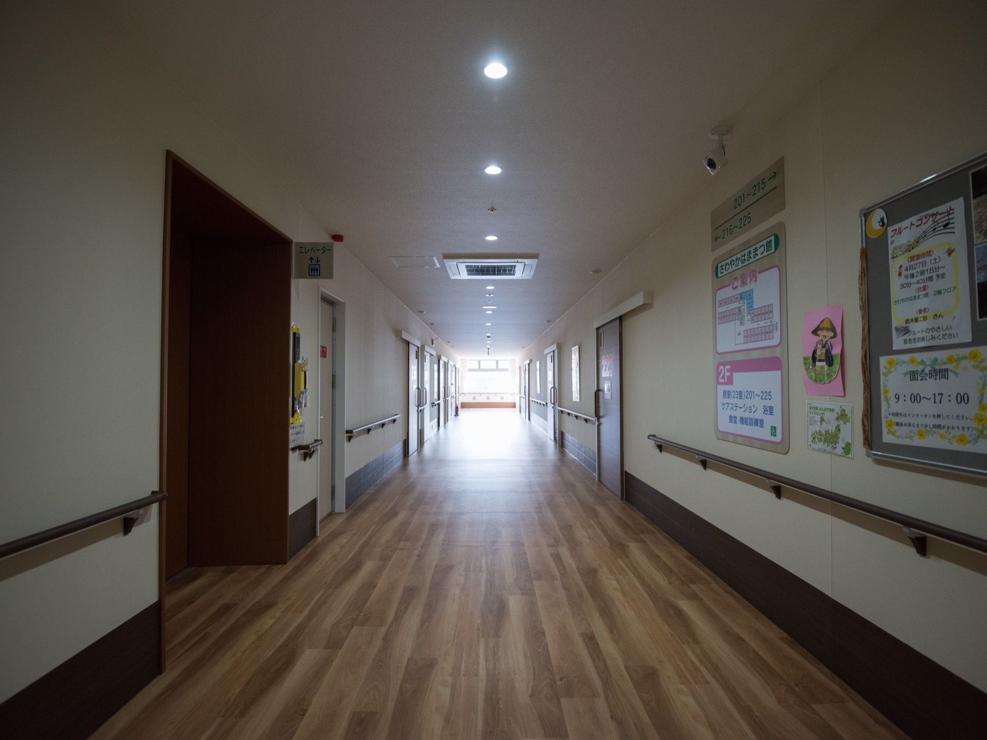 横幅のある廊下で、天井には等間隔で照明が設置されている。突き当りにある窓からは、外光が差し込んでいる。