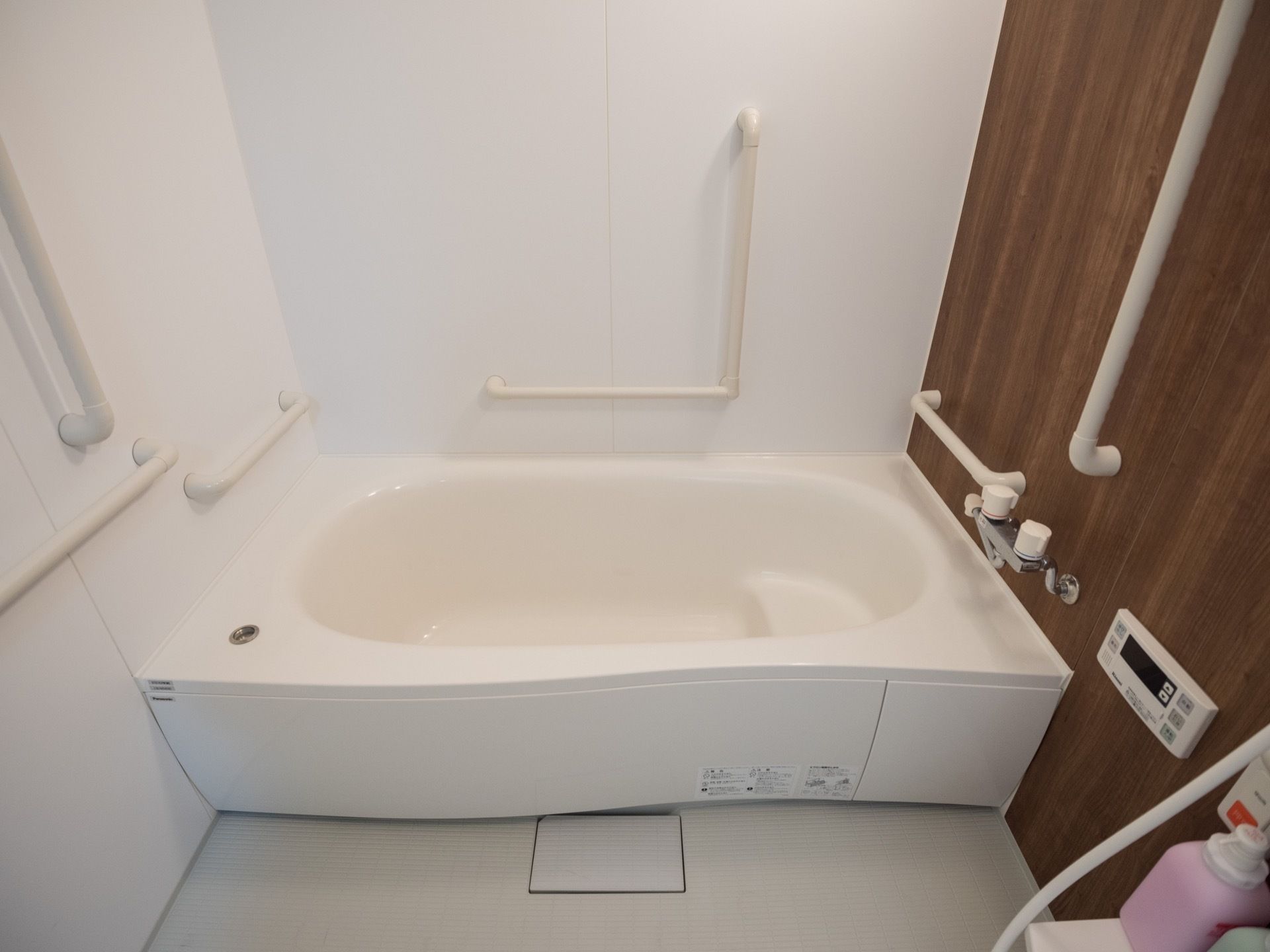 複数の手すりが設置されている一般浴室。浴槽内には、ゆっくりと腰を掛けられるよう工夫されたデザインになっている。