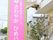 施設前の芝生の上に、ピンクの地に白色で施設名を書いた看板が立っている。遠くからでも目に付きやすくなっている。