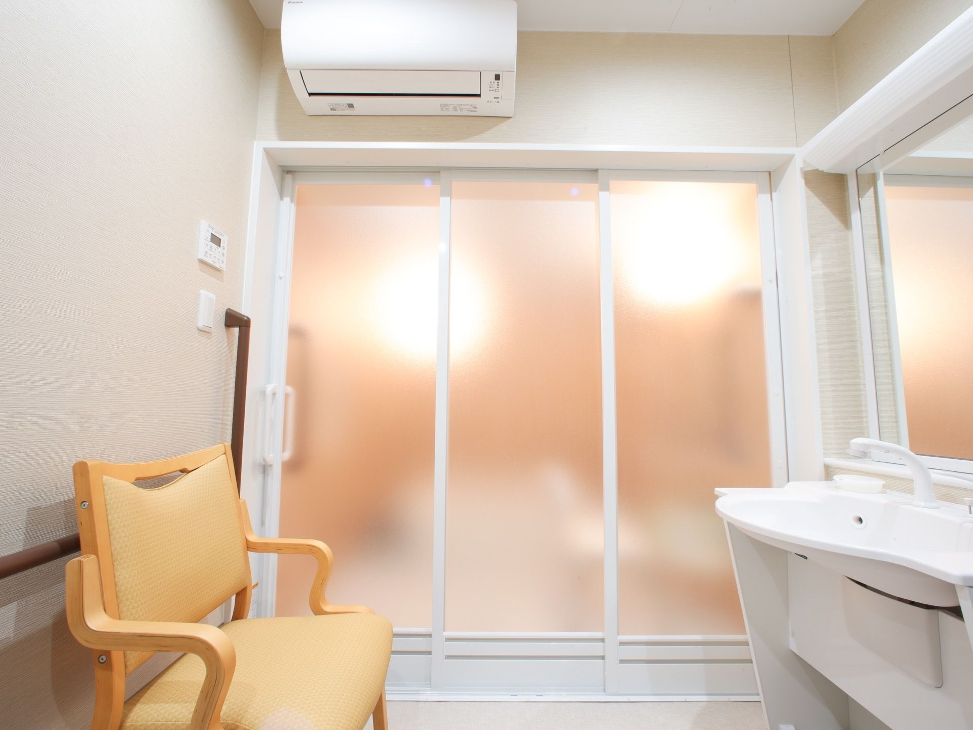 エアコンと洗面台が完備された脱衣所には入浴する際、安全に衣服を着脱できるように手すりと椅子を配備している。