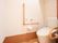 トイレには便器の足元にマットが敷かれている。手すりや呼び出しブザーも設置されており安全である。壁の上部に棚が設置されている。