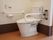 スタイリッシュなトイレを設置している。両側に手すり、壁には緊急呼び出しボタンとトイレリモコンなどが備え付けられている。