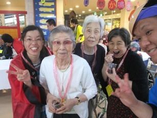 お祭り広場で、笑顔を見せて並んでいる入居者とスタッフ