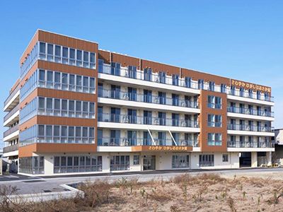ガラス窓が多く設置されている、重厚な造りをした五階建ての施設外観