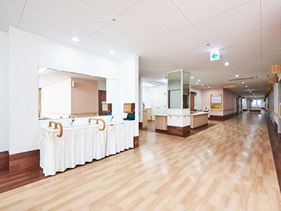 木目調のフロアと白い壁紙が、明るく開放的な空間になっている。安全に配慮して、壁には手すりが取り付けられている。