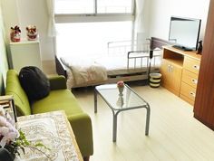 窓際に手すり付きのベッドが置いてあり、部屋には生活に必要な家具が揃っている。テーブルには花が飾られており、明るい雰囲気である。