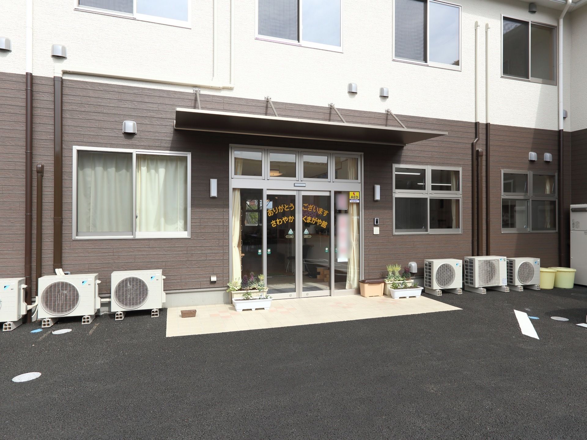 施設の入口はガラスの自動ドアになっている。自動ドアには施設の名前は印字されている。外からは段差もなくスムーズに出入りできる。