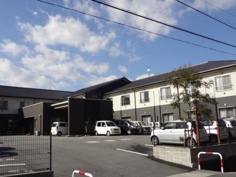 2階建てでツートンカラーが特徴の建物。駐車スペースは広くなっており、施設と隣接している。距離が近く便利である。