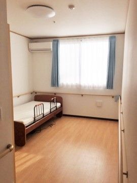 部屋の壁一面に手すりが設置されているシンプルな居室