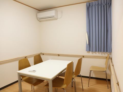 壁一面に手すりが設置され、中央にテーブルセットが置かれている部屋