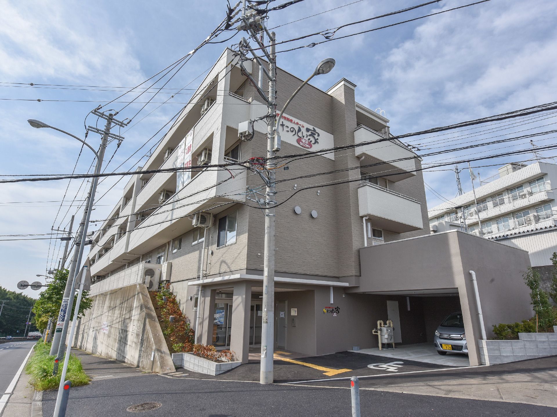 周囲には、坂道が多くあるが、外部の道路から玄関へは、段差はなく、バリアフリーになっている。屋根付きの専用駐車場がある。