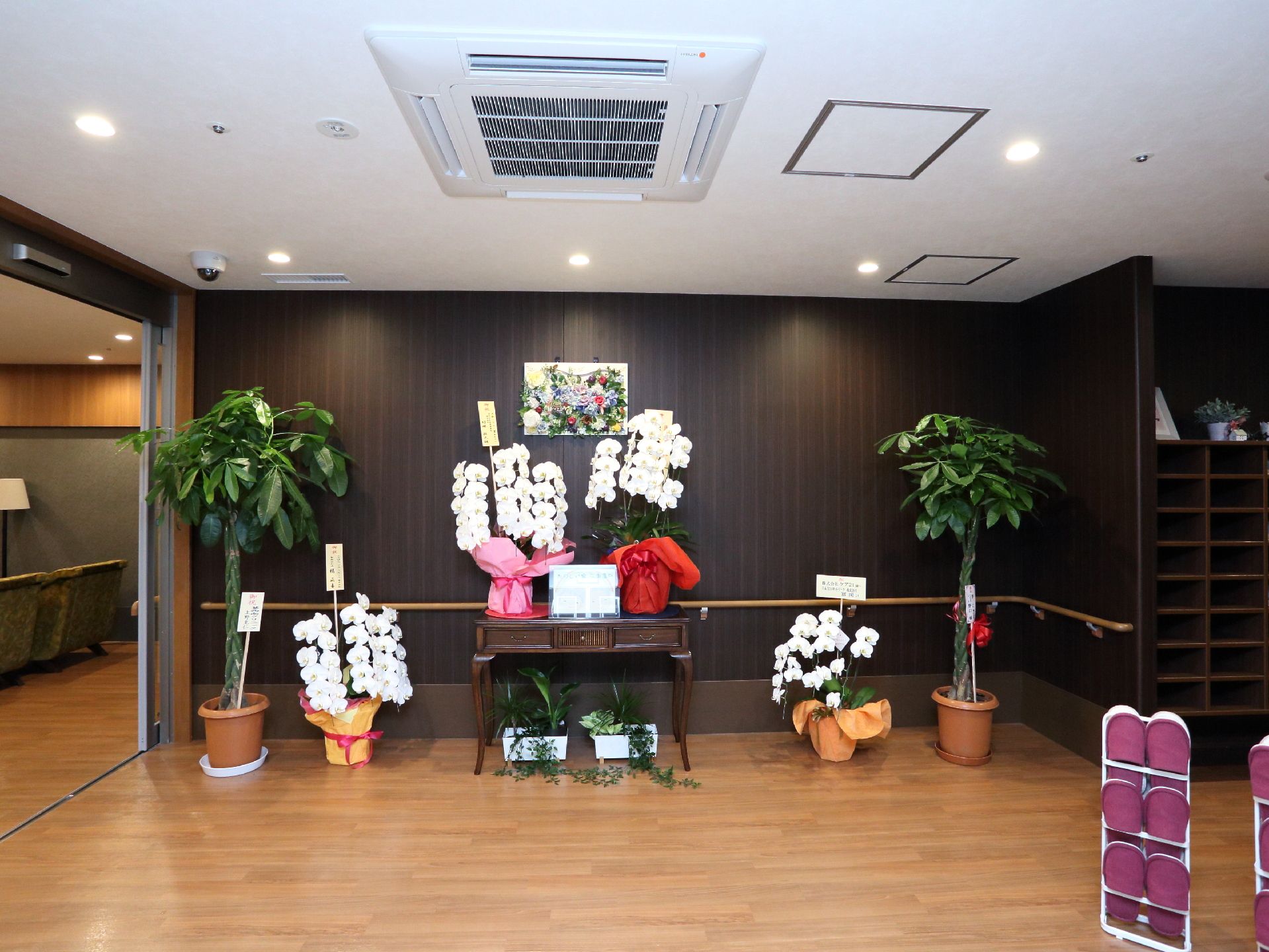 ロビー正面にはお祝いの花が多数飾られている。落ち着いた色合いになっており、来所者に安心感を与えている。