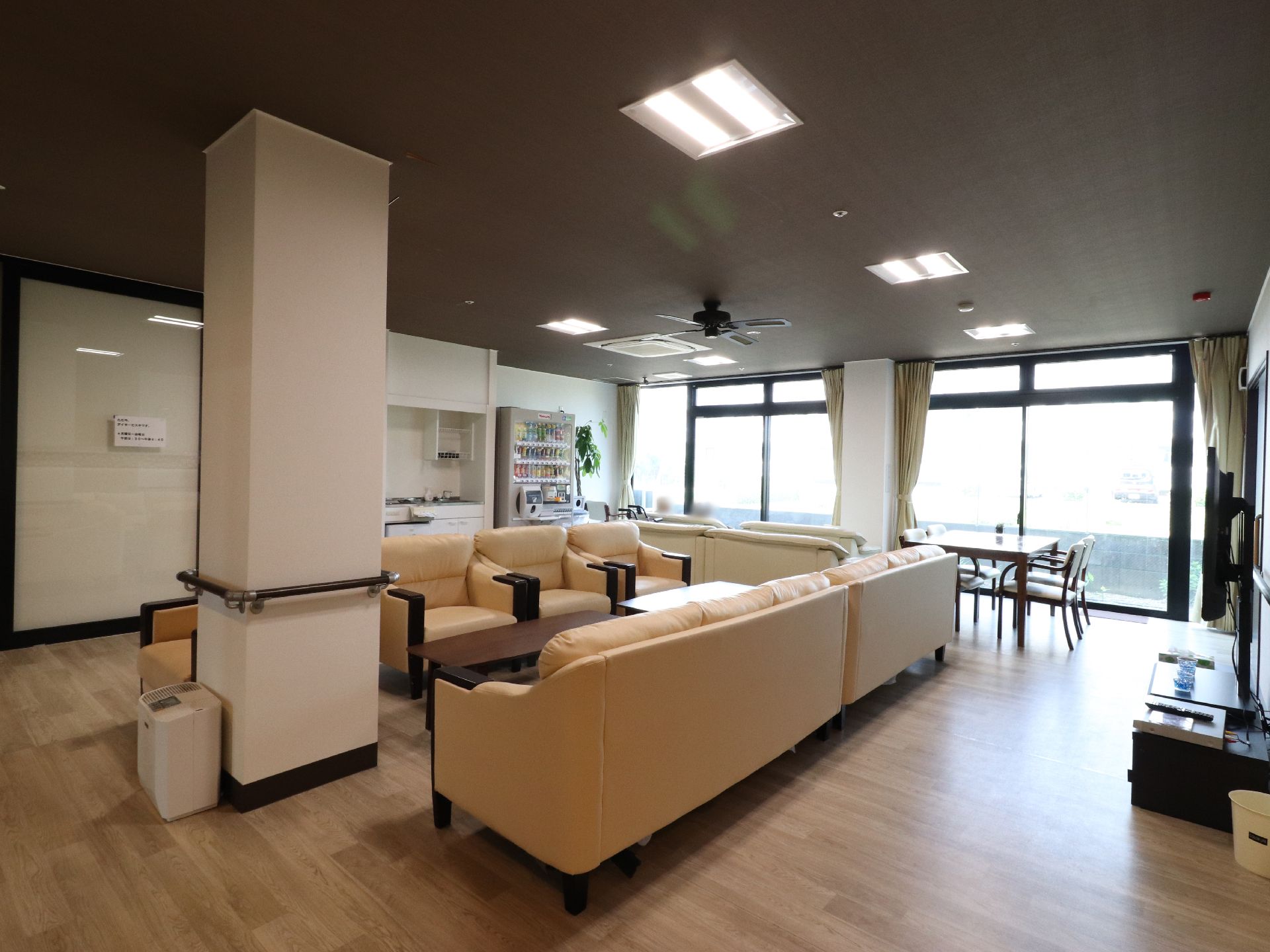 ゆったりした部屋の一面はガラス張りになっており陽光が差し込んでいる。クリーム色のソファが何台も向かい合わせで並んでいる。