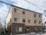 ベージュトーンで統一された落ち着いた印象の建物。スロープはなだらかで利用しやすい。駐車スペースもある。