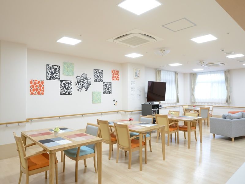三人の若い男性スタッフが、横並びになってポーズを取っている様子