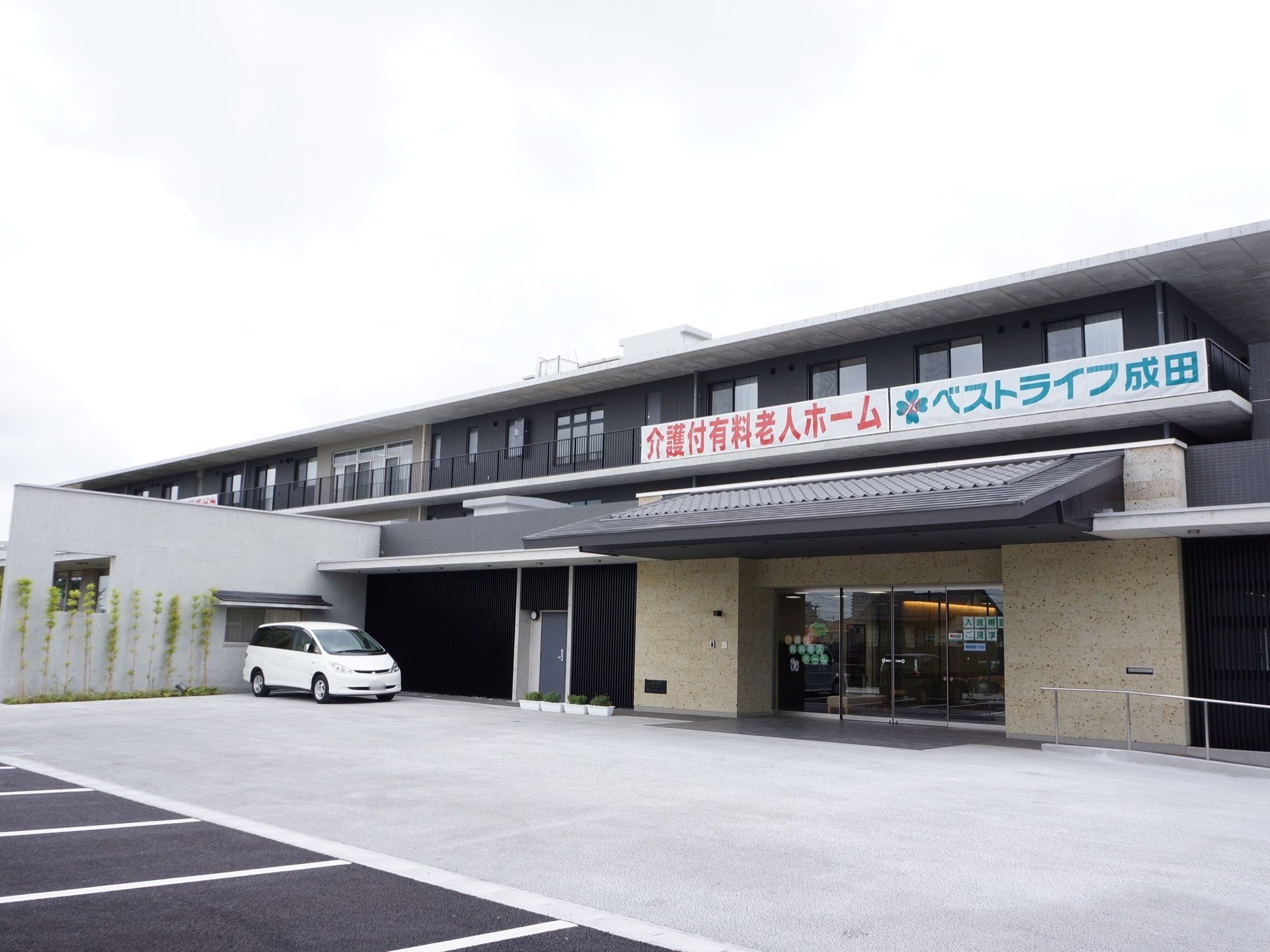 2階建ての建物前のスペースに駐車場がある。玄関前の軒下に車を寄せることができる。また、足元には段差のない設計である。