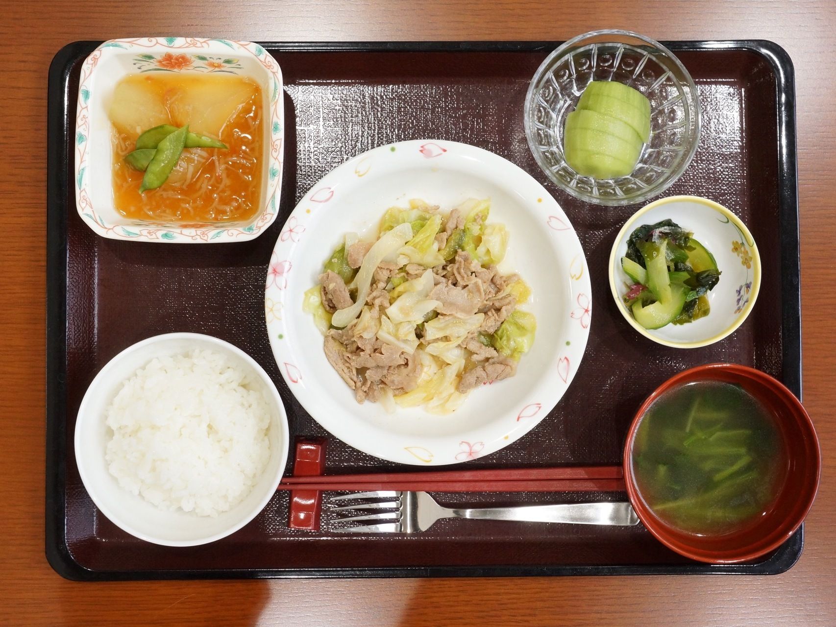 トレーにのった食事の写真。肉や野菜が使われたバランスのよい内容になっている。また、箸のほかにフォークも用意されている。