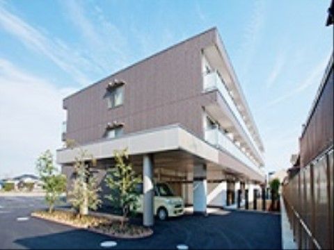 建物の玄関前が吹き抜けになっており、その部分を黄色い車が通過している様子