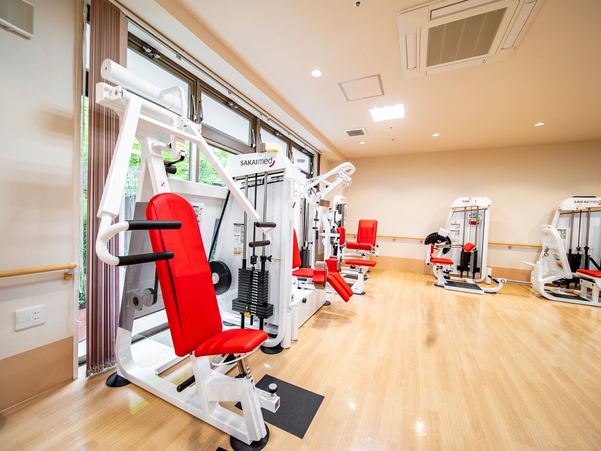 トレーニングマシーンが並んでいる部屋である。白と赤と黒が使われたスタイリッシュなデザインのものである。