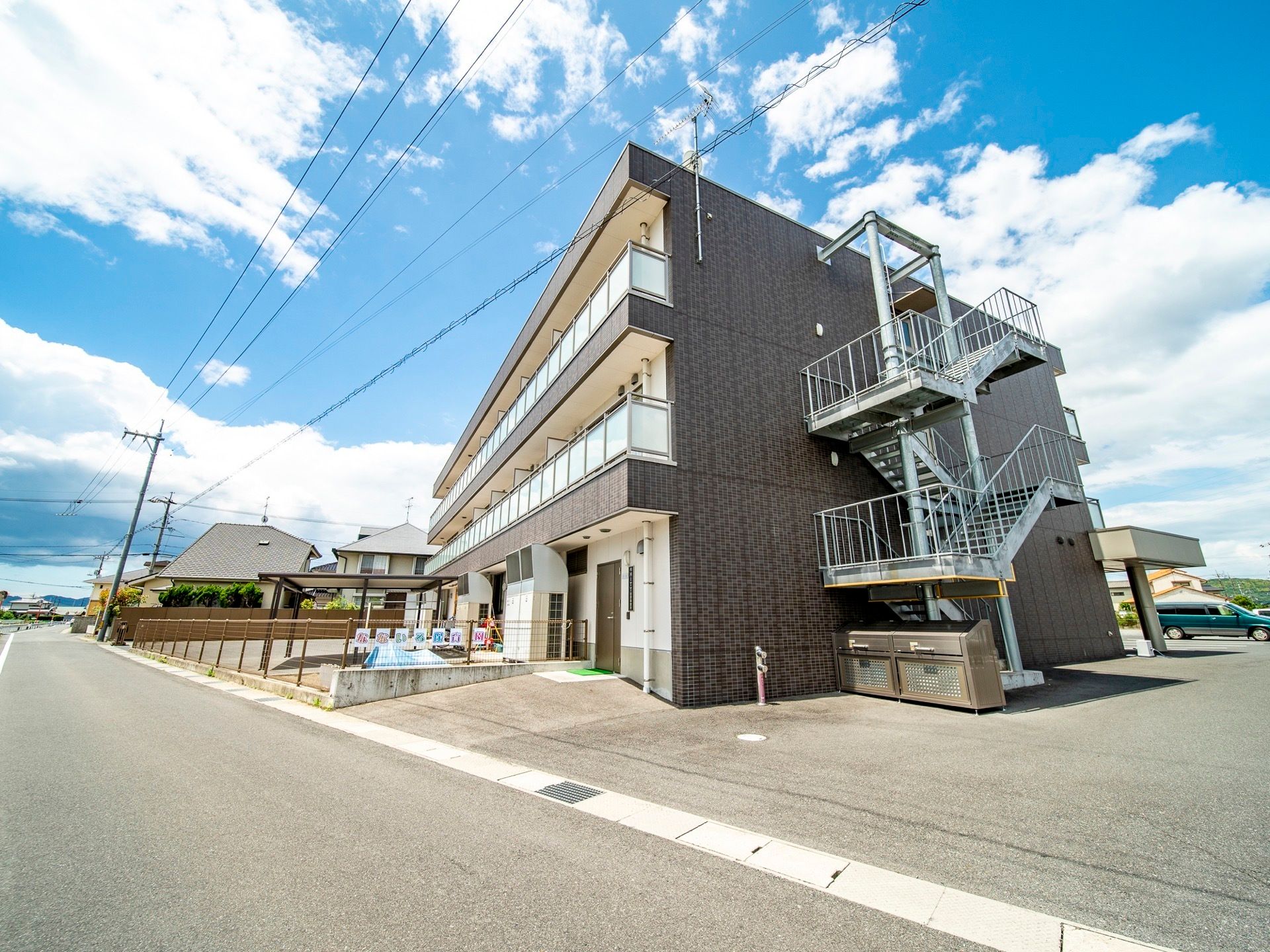 グレーを基調とした外装の、お洒落な３階建ての建物である。周囲には背の高い建物がなく、見晴らしが良い。側に大きな駐車場がある。