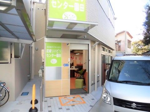スライド式の玄関ドアや、雨よけルーフの上の壁に施設名が掲示されている建物入口