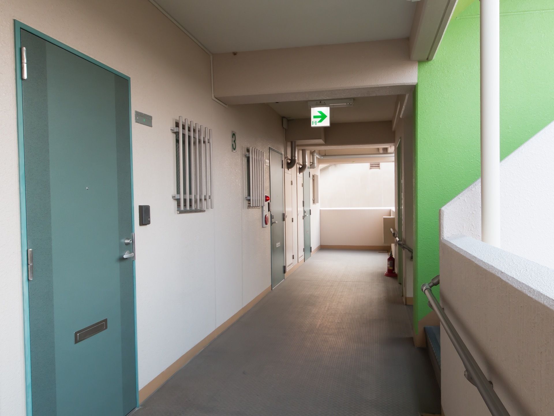 マンションのような構造になっている。居室の入口扉は、緑色の開き戸である。小さな窓には防犯のための格子が設置されている。