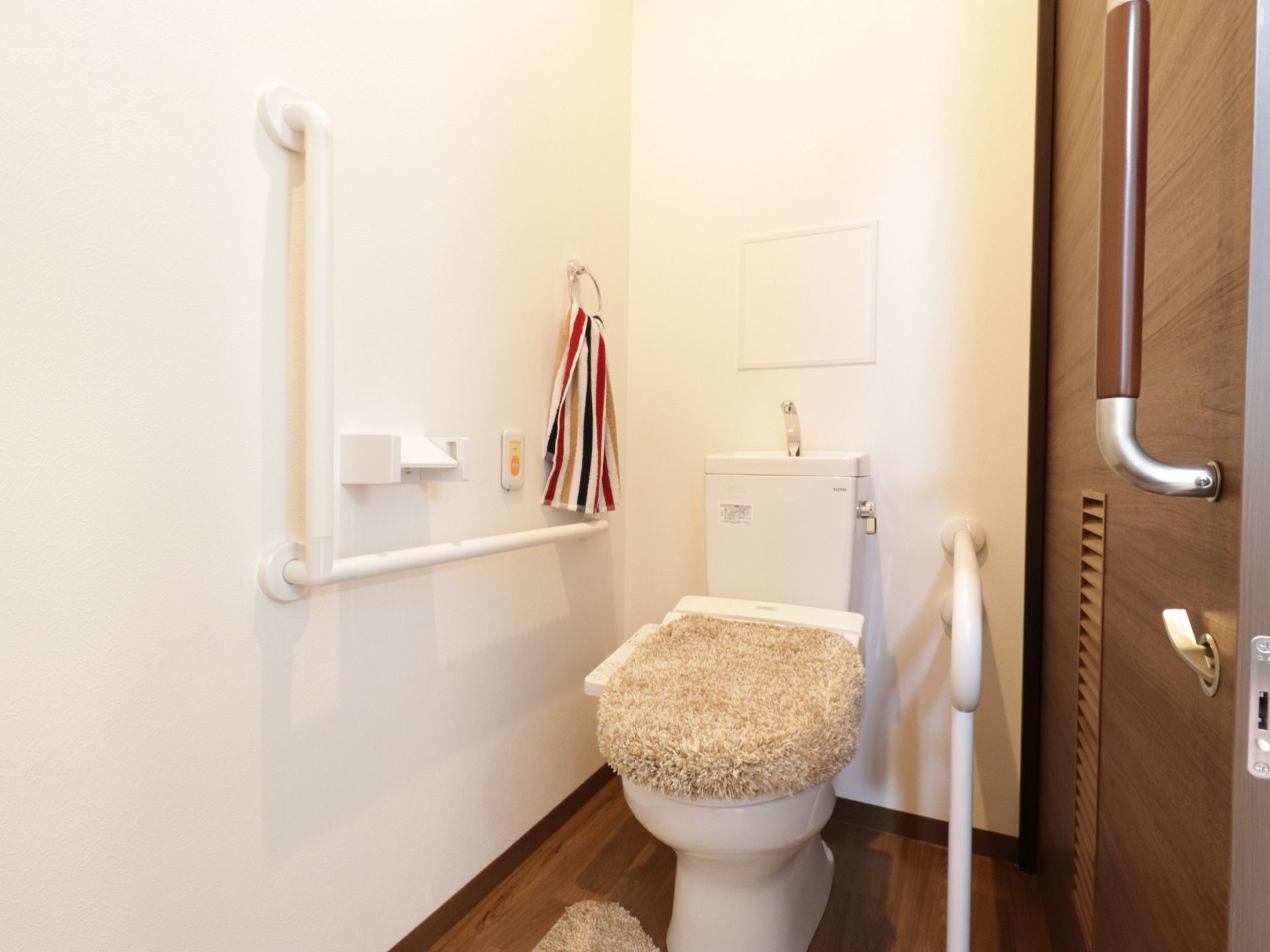 居室のトイレは、壁と便器の横に手すりが設けられており、緊急時ボタンも取り付けられているので、安心して使用できる。