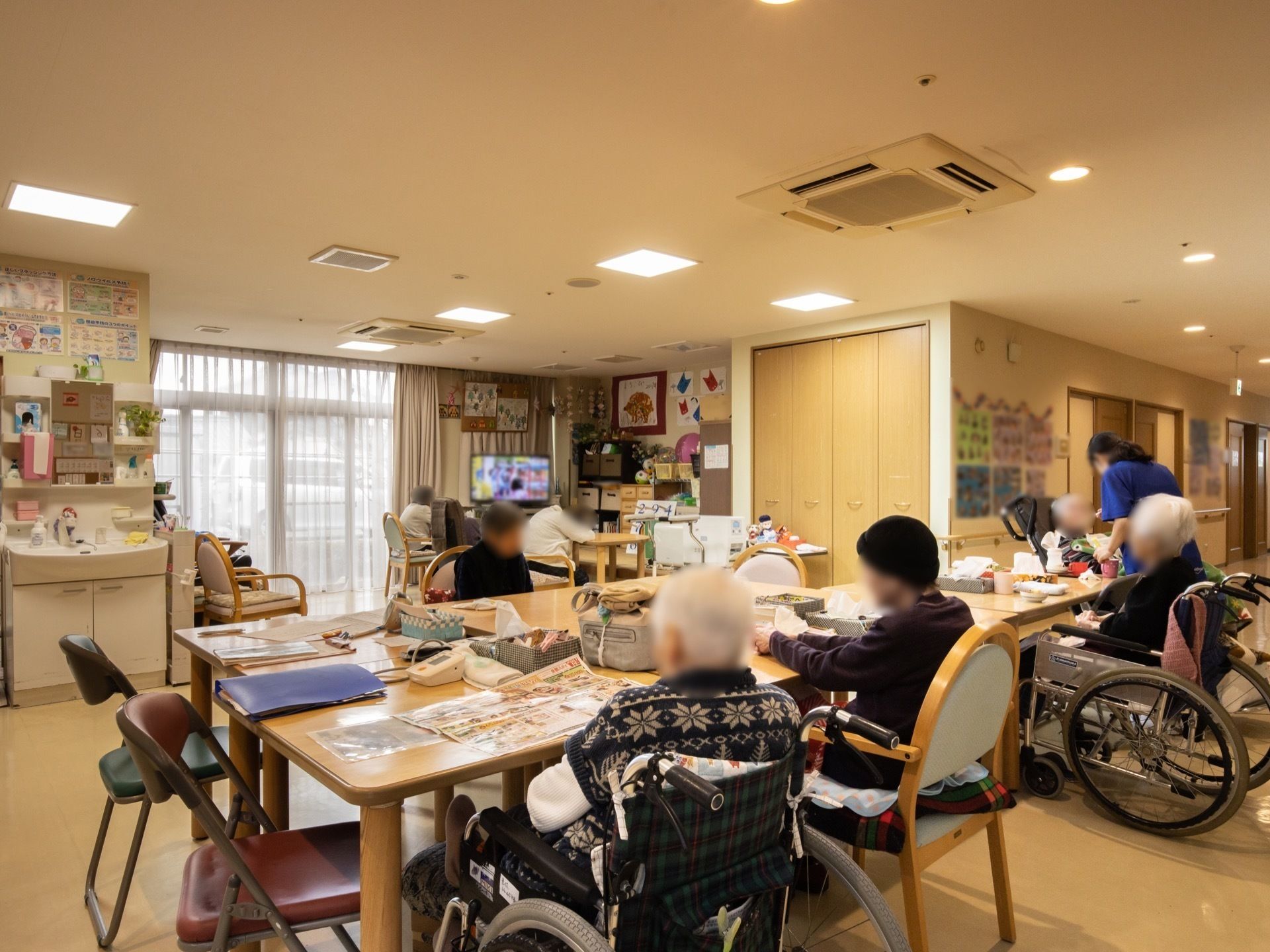 リビングルームで、新聞を読んだりテレビを観たり、各々好きなことをして過ごしている入居者たち