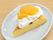 デザートののったお皿。丸いお皿の上に切り分けられたケーキがのり、クリームとみかんがトッピングされている。