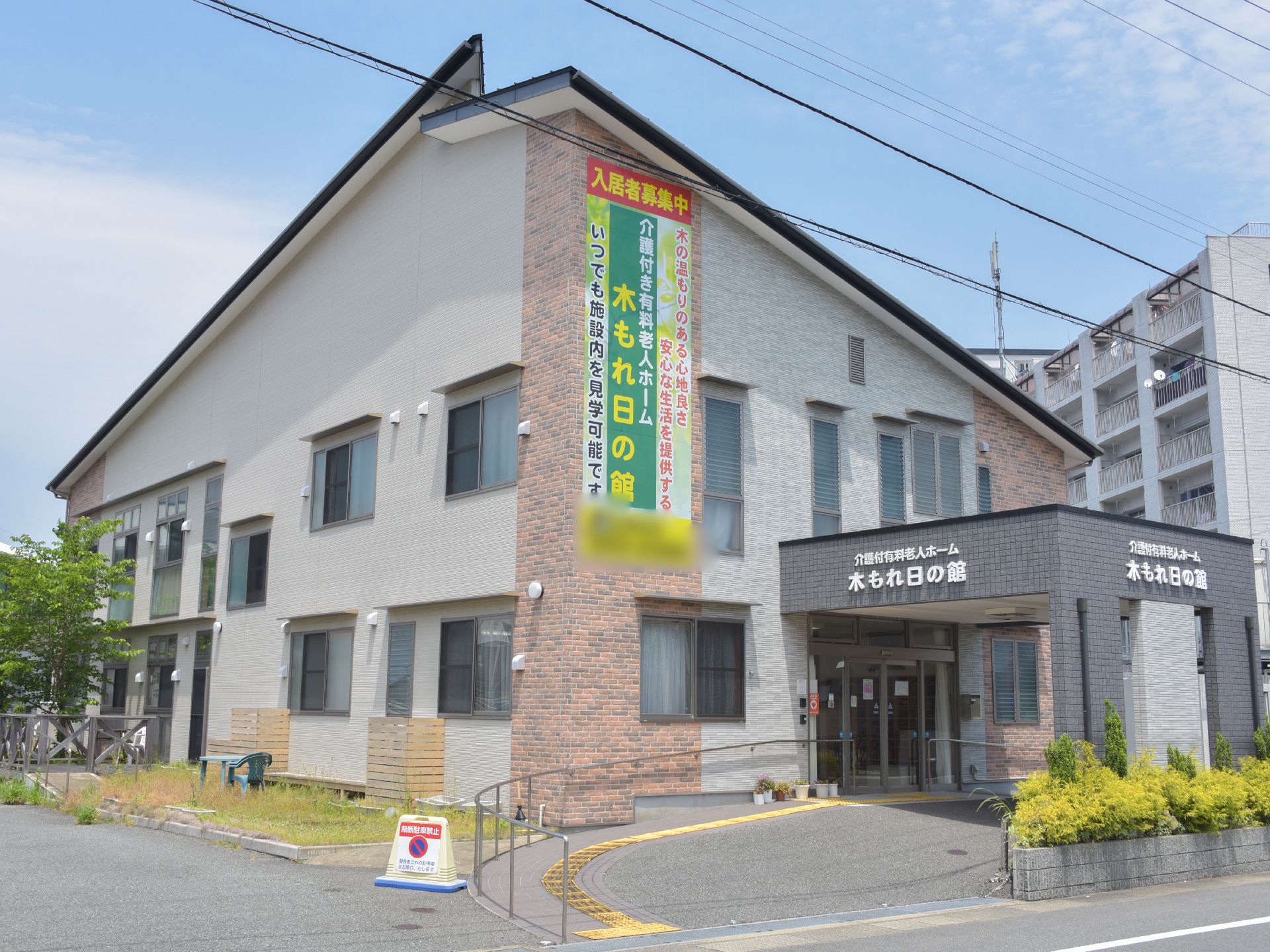 住宅街の中にある施設の外観。車道から玄関入り口まで緩やかなスロープが付いている。また車でも玄関につけやすい。