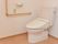 清潔感のある洋式トイレには、L字型のしっかりした手すりが設置されている。また呼出ボタンがあるので安心できる。