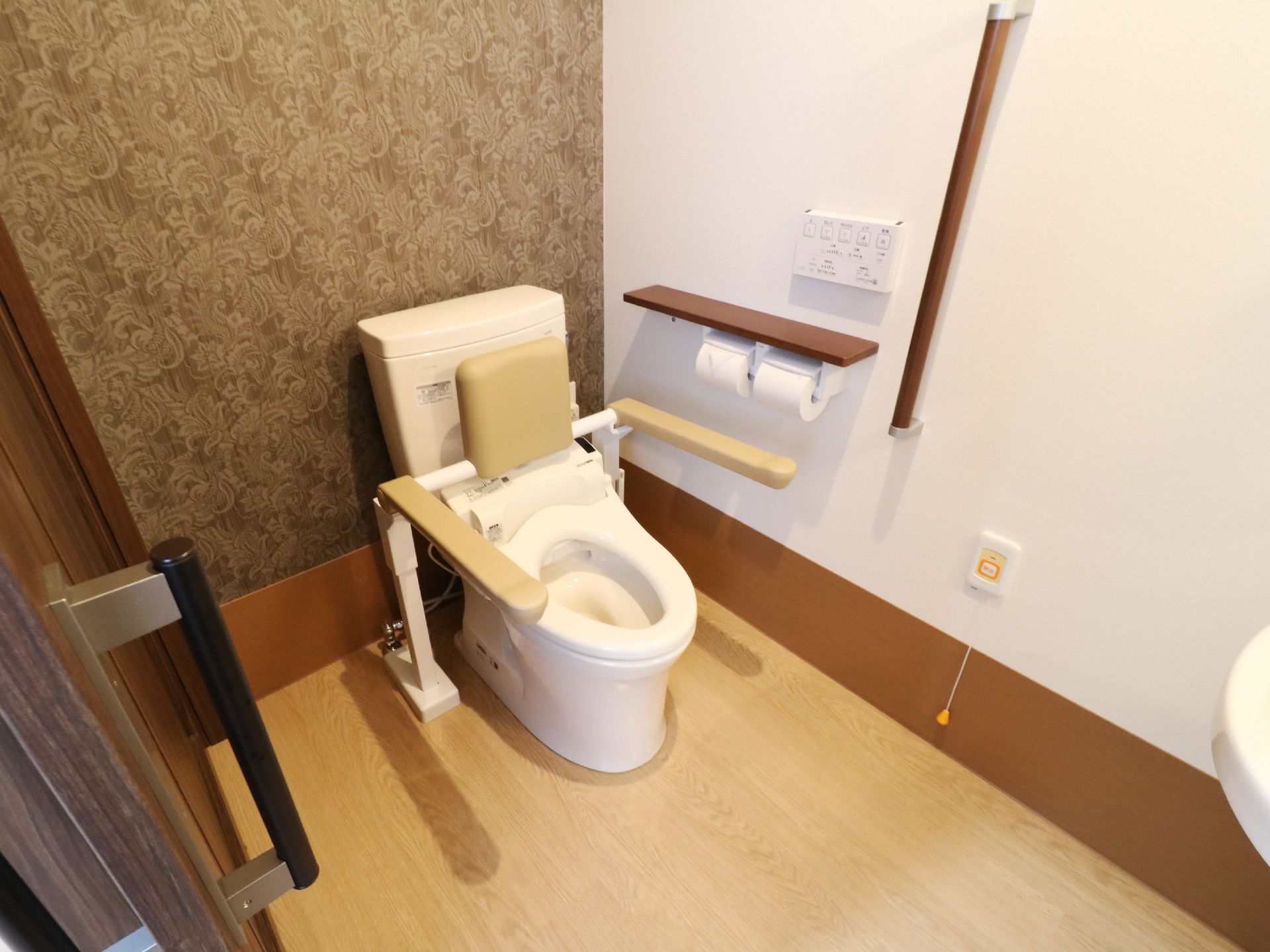トイレは十分なスペースを確保しているので、車椅子の方にとっても介護をする方にとっても便利である。壁には呼出ボタンが設置されている。