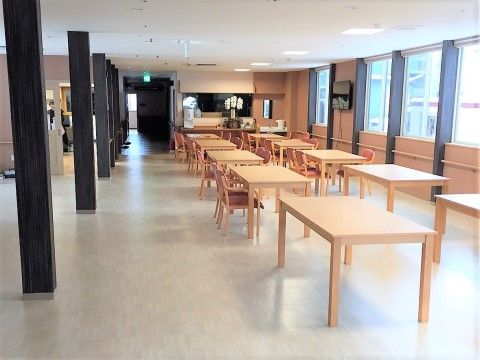 白に近いフローリングや明るい木目調のテーブルの”白さ”と、空間中央に直線状に並んだ柱の”黒さ”との対比がユニークな共有スペースである。