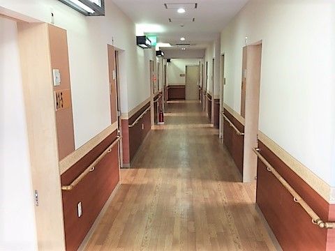 入居者様の居室区画内を伸びる廊下は、通行の安心・安全に配慮して、壁に隙間なく手すりを設け、幅もゆったりと広くとった設計となっている。