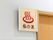 風呂の入口扉の上部に、赤い温泉マークと共に福の湯と名前が入ったベージュの四角い看板が付いている。シンプルな看板が、白い壁に映えてよく目立つ。