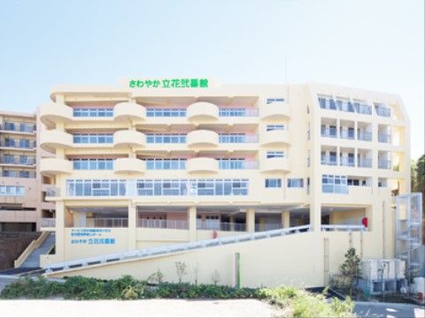 全体的に外壁がクリーム色をしている、窓がたくさん設置された施設外観