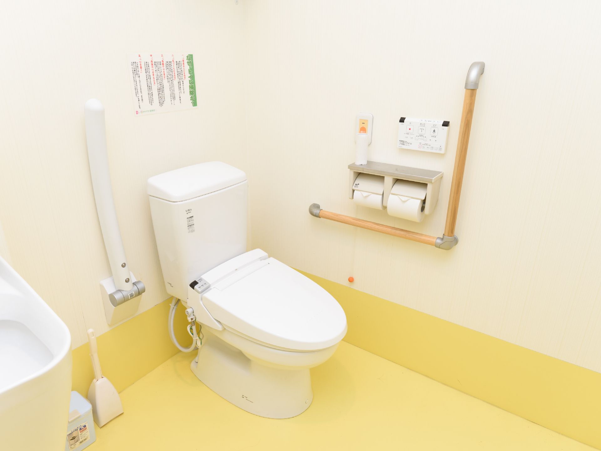 トイレはふたつきの便座になっている。便座に座って右側には、可動式のひじ掛けがある。ナースコールボタンがある。