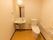 洗面台とトイレが隣り合っている。洗面台には鏡や照明、タオル掛けが付いており、レバー式水栓になっている。