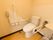 大型の手すりが、トイレの左右の壁に設置されている。奥にはペーパーホルダーが２つあり、その斜め上には電話もある。